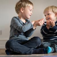 Søskendepar, to drenge, sidder og leger 